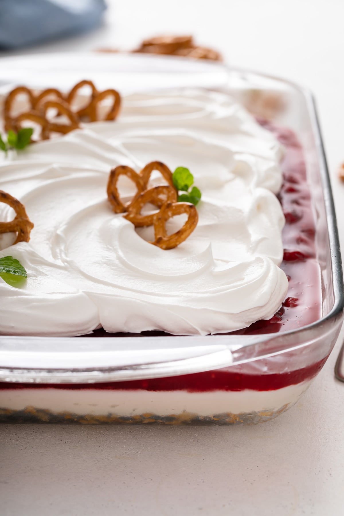 Cherry cheesecake pretzel salad in a glass pan.