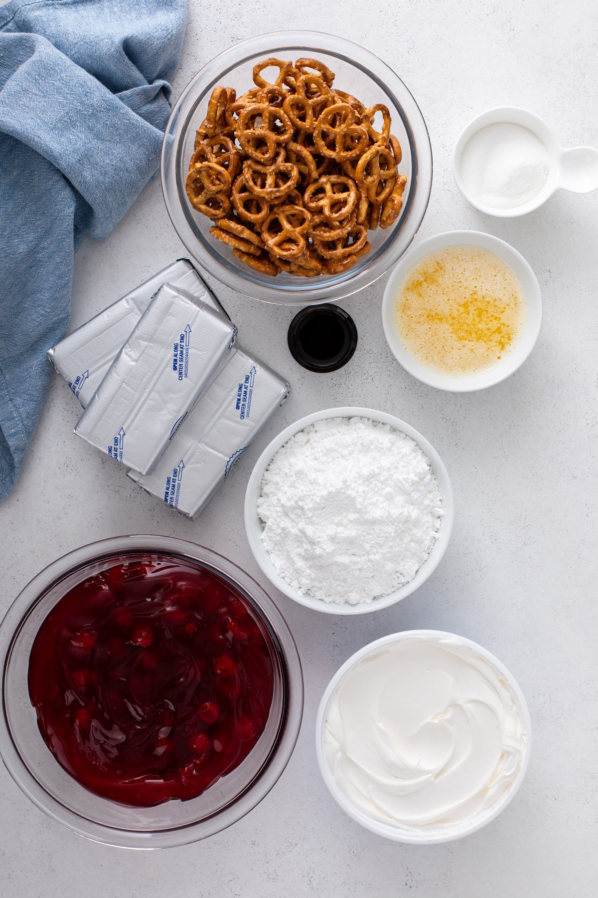 Ingredients for cherry pretzel salad arranged on a countertop.