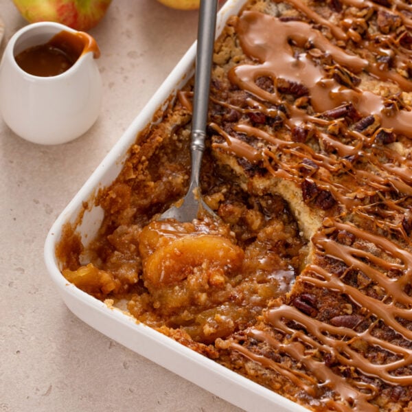 Spoon in the corner of a pan of caramel apple dump cake.