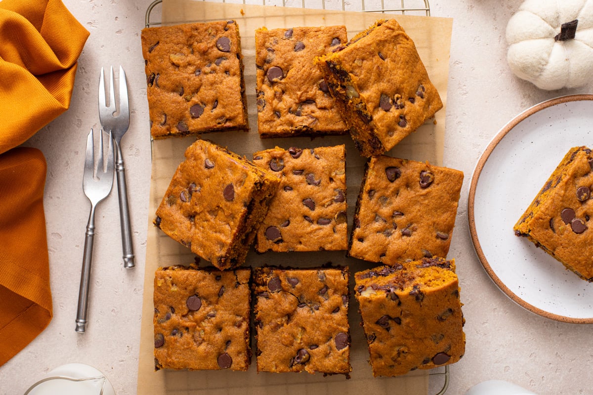 Overhead view of slices of pumpkin chocolate chip snack cake arranged on a wire rack.