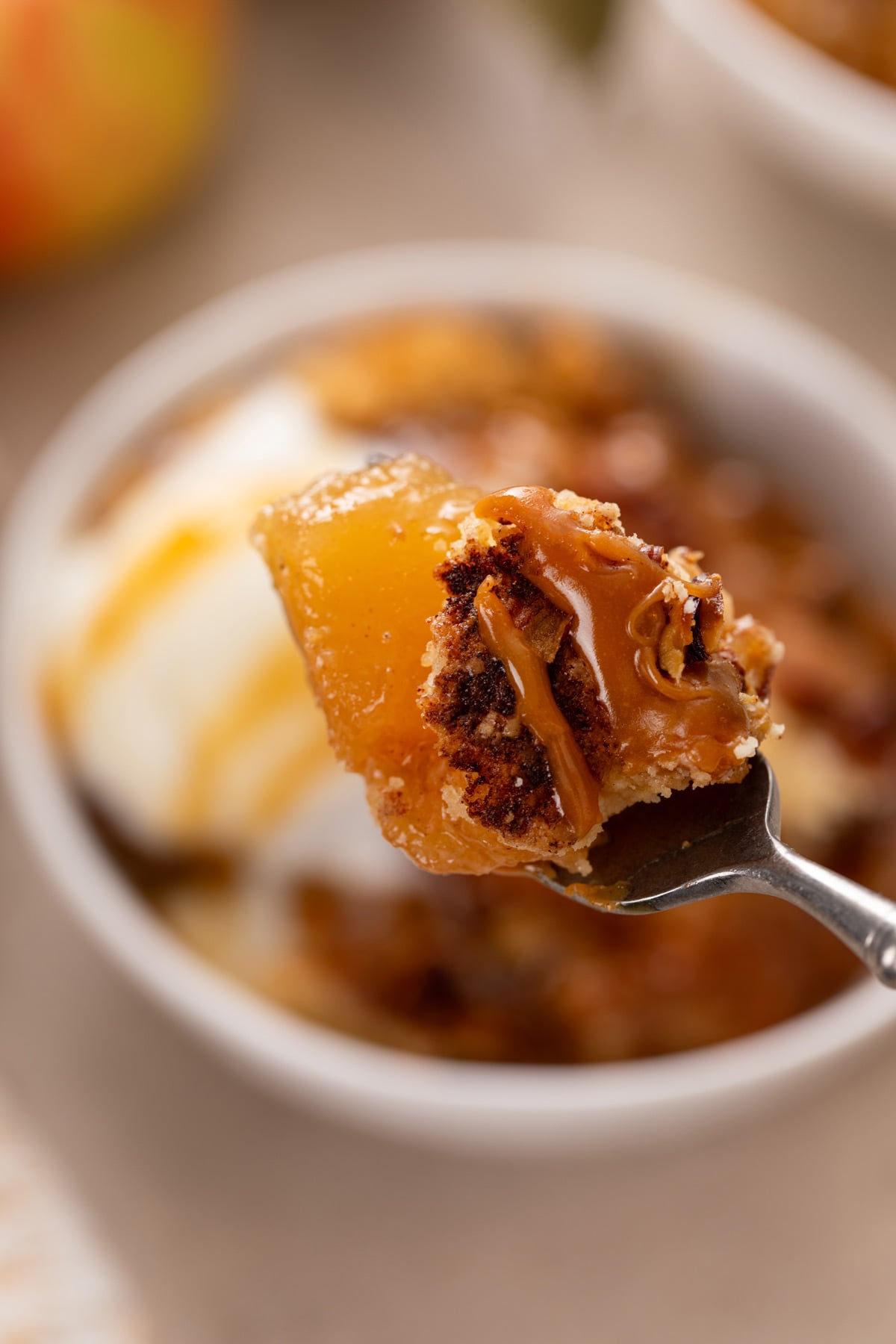 Fork holding up a bite of caramel apple dump cake.
