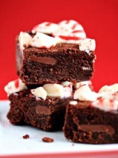 Three peppermint brownies on a plate on a red surface