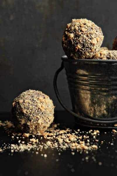 Small metal bucket filled with s'mores truffles with a truffle next to it on a black surface